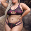 A plus-size model wears a pink and black plaid print bralette and panty with an underbust cutout and strappy panty sides.