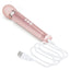 A Le Wand rose gold petite vibrator lays against a white backdrop and shows its charging cord attached at the base. 