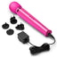 A magenta vibrating massager by Le Wand lays next to its charging cord and two international wall plugs. 