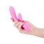 A manicured hand holds a light pink silicone G spot rabbit vibrator for scale