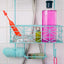 A Romp Pop red clitoral vibrator sits in a shower caddy, surrounded by bathroom amenities to show its waterproof design.