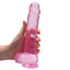 RealRock 9" Crystal Clear Realistic Dildo With Balls & Suction Cup has a lifelike sculpted phallic head, veiny shaft & testicles for safe anal or vaginal play. Pink-on hand.
