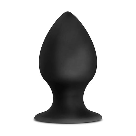 A black silicone butt plug stands against a white backdrop with a girthy 2-inch wide design. 