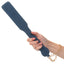 A hand model holds a denim spanking paddle with a gold chain around her wrist.