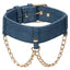 Back view of a denim collar with gold chains draped on either side of the collar's clasp.