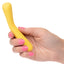A hand model holds a mini yellow wand vibrator for scale.