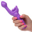 A hand model holds a purple butterfly rabbit vibrator for scale.