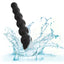 A black silicone anal bead wand is shown in water showcasing its waterproof design. 