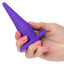 A hand model holds a purple vibrating anal probe for scale and showcases a tapered tip.