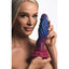 A female model holds a silicone alien-themed dildo with a rippling base ring. 