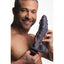 A male model holds a pastel purple sea monster phallic shaped dildo. 