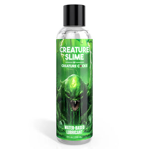 A clear bottle of clear gel with black lid and green label of a slime-covered monster and the text 'Creature Slime'