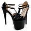 A pair of patent black Ellie Venus platform stiletto heels with T-straps and closed toes sit against a white backdrop.