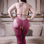 Back view of a plus size model wearing a burgundy fishnet body stocking featuring strappy back detail.