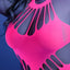 Close up of a plus size model wearing a pink glow in the dark bodystocking featuring keyhole cutouts above and below bust.
