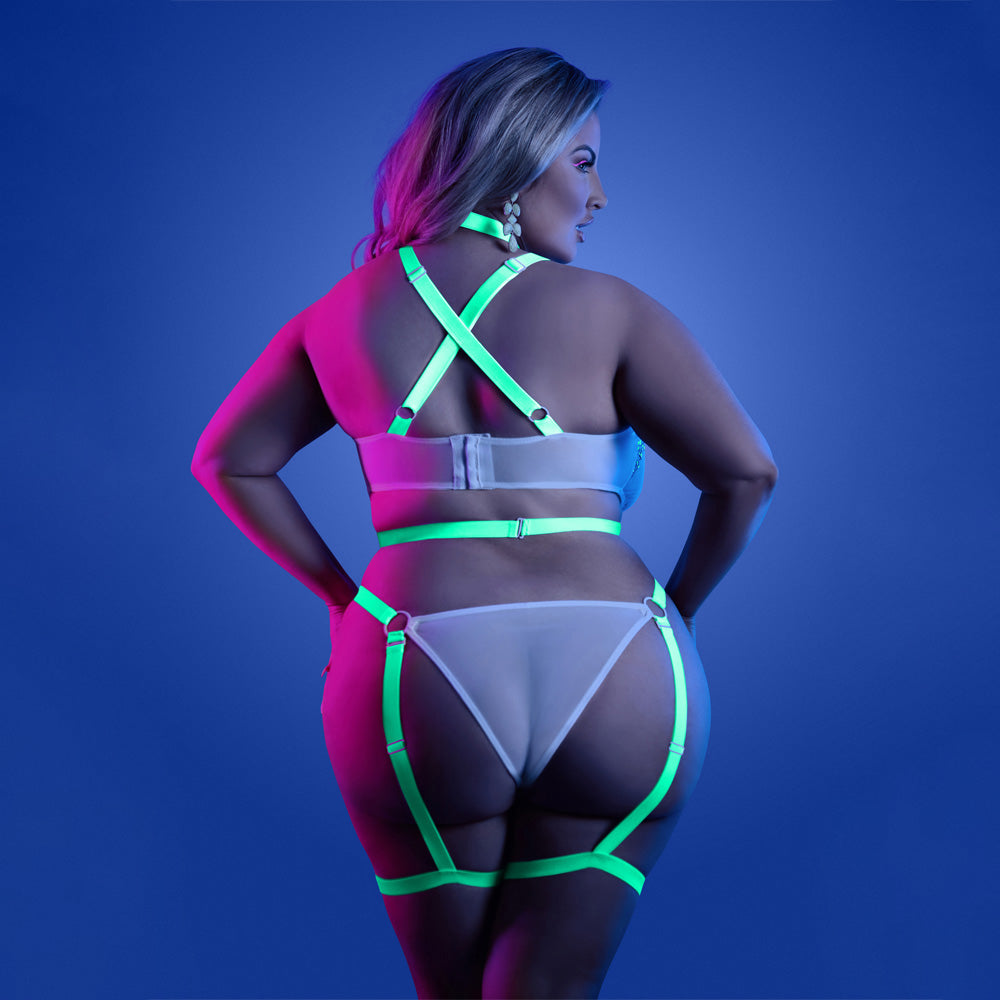 Back view of a plus size model wearing a glow-in-the-dark cage strap teddy that has swan hook and hook and eye closures.
