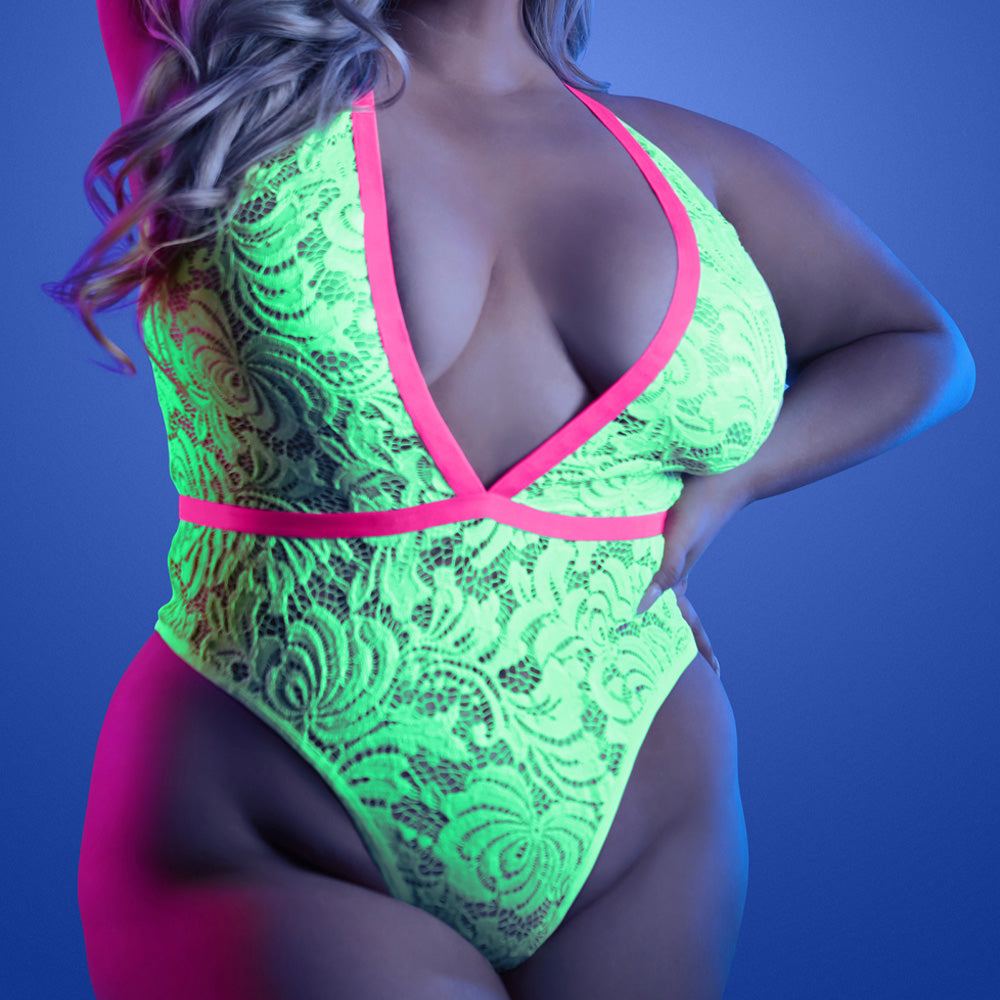 A plus-size model wears a pink and green glow-in-the-dark floral lace teddy with a plunging V-neck and contrast trim.