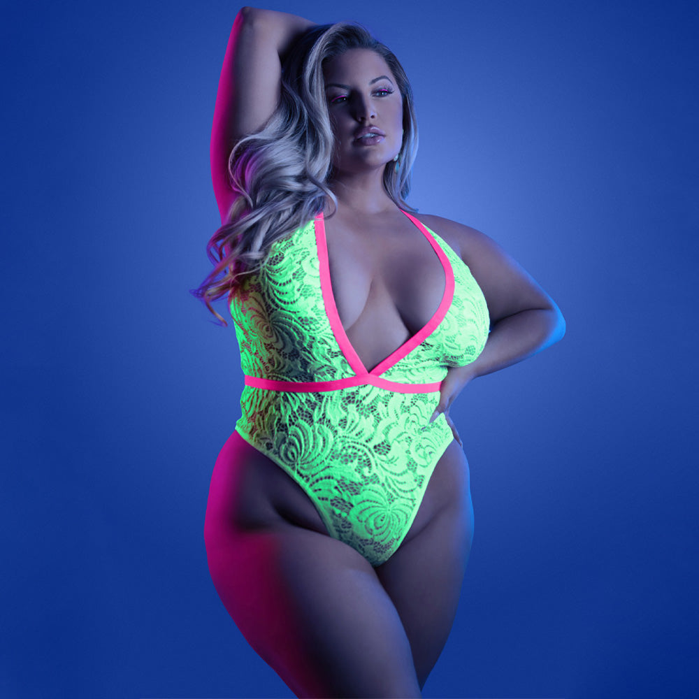 A plus-size model wears a neon glow-in-the-dark floral lace teddy with contrast elastic trim around the bust and waistband.