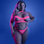 A plus size model wears a neon pink glow in the dark net bra and panty with collared halter neck and O-ring detail.