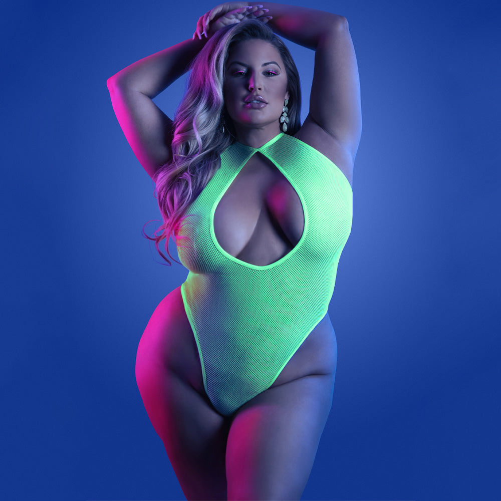 A plus size model wears a neon green glow in the dark teddy featuring a collared halter neck.