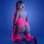 A plus-size model wears a neon pink crotchless bodystocking with figure-8 suspenders to hold the attached leggings.