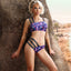 A model wears a purple bandeau style bra and panty set with a galaxy-inspired planet pattern.