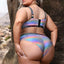 Back view close up of plus size model wearing holographic bra and panty with hook and eye closure on back of bra. 