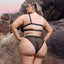 Back view of a plus size model wearing a sheer black crop top and panty with a swan hook closure in the dual-strap back.
