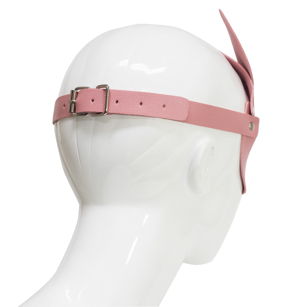 A back shot of a pink faux leather fox face mask worn on a mannequin head shows its adjustable silver rear buckle closure.