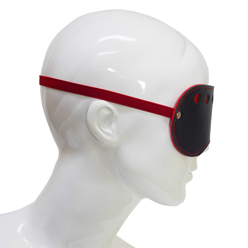 A side view of a mannequin wearing a black and red eye mask shows the elastic strap wrapping around the mannequin's head.