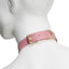 A back view of a pink faux leather collar showcases an adjustable gold buckle and tail keeper around a mannequin's neck.
