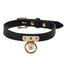 Front view of a slim black leather collar with a gold T-plate affixing the gold O-ring against a white background.