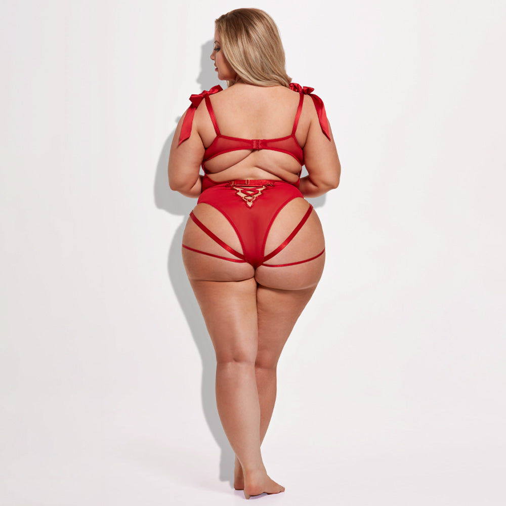 A plus-size lingerie model wears a red teddy with a strappy rear and criss-cross details at the small of the back.