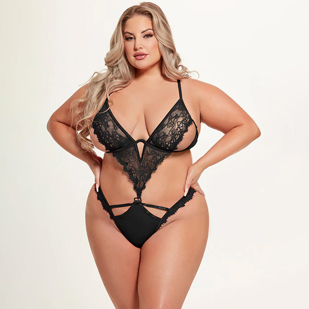 A plus-size model wears a sheer lace teddy with a V-shaped lace panel and cutouts at the waist and sideboob.