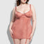 A plus-size model wears a light pink sheer mesh gartered chemise and G-string with rounded piping details in the front.