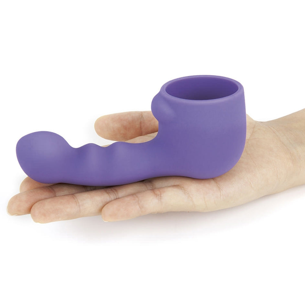 A hand holds a Le Wand silicone violet attachment which shows the opening sleeve.