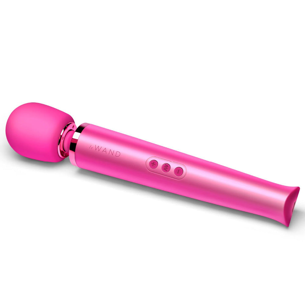 A magenta vibrating massager lays on a white backdrop and features a soft silicone head. 