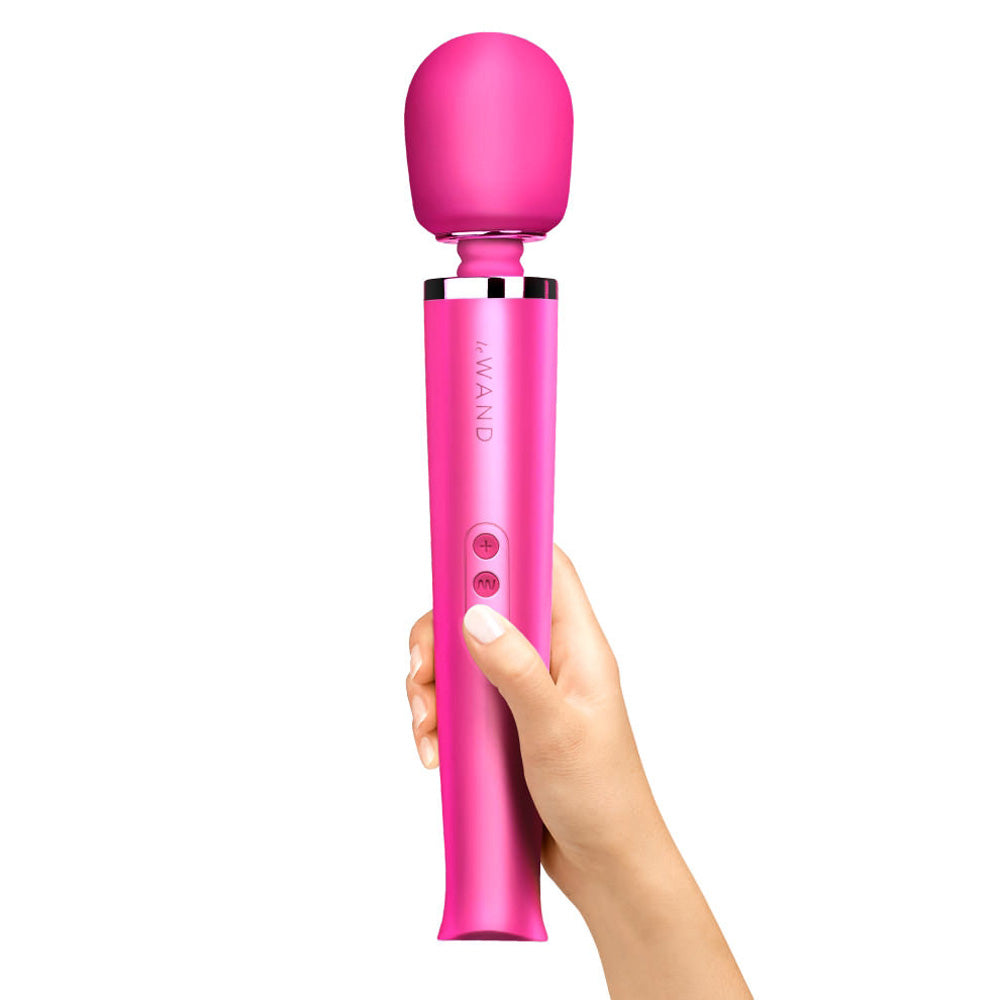 A hand model holds a magenta vibrator against a white backdrop that showcases two control buttons. 
