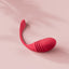 Editorial image of the Lovense Vulse hands-free thrusting G-spot egg vibrator laying against a pink background.