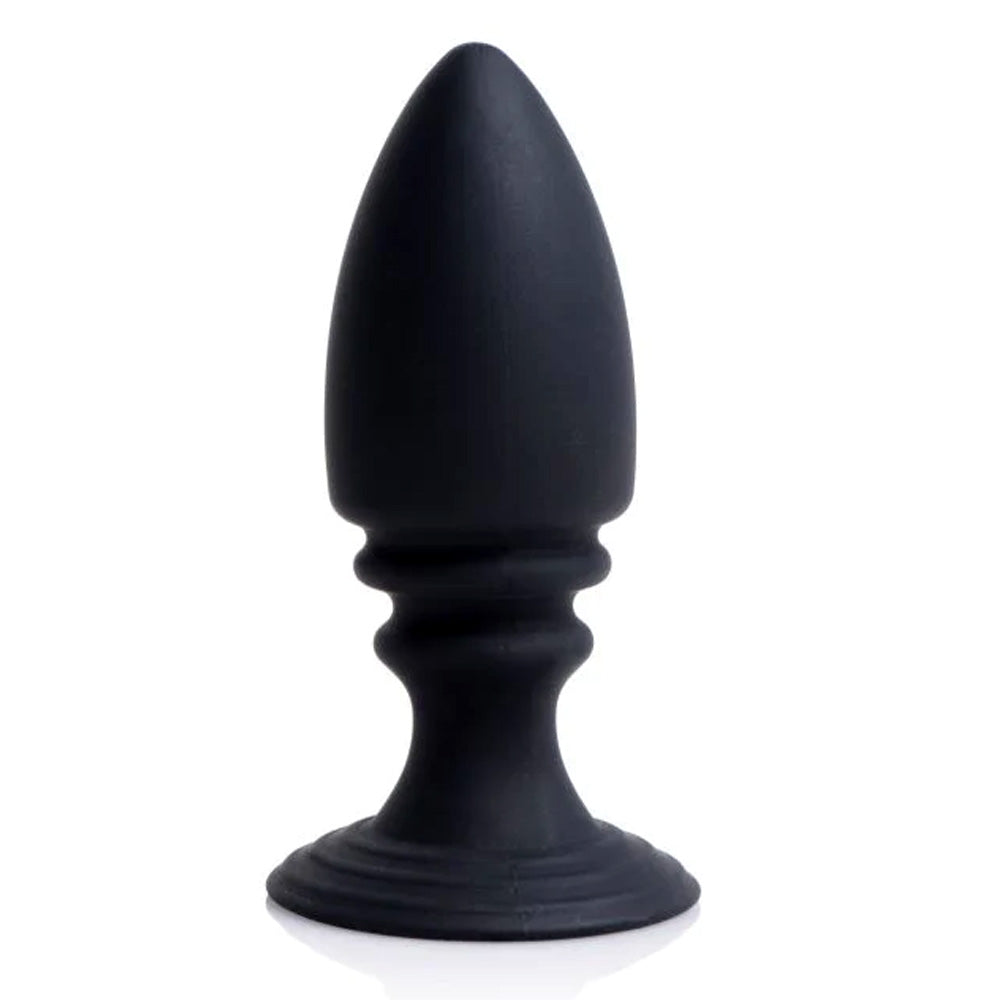 The black silicone anal plug that comes included with the Strict chastity harness stands alone against a white backdrop.