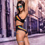 Back view of a model wearing a cutout crop top and panty with a rainbow motif framing a cutout at small of the back.