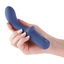 A hand model holds a blue curved design vibrator with a textured power button on the handle. 
