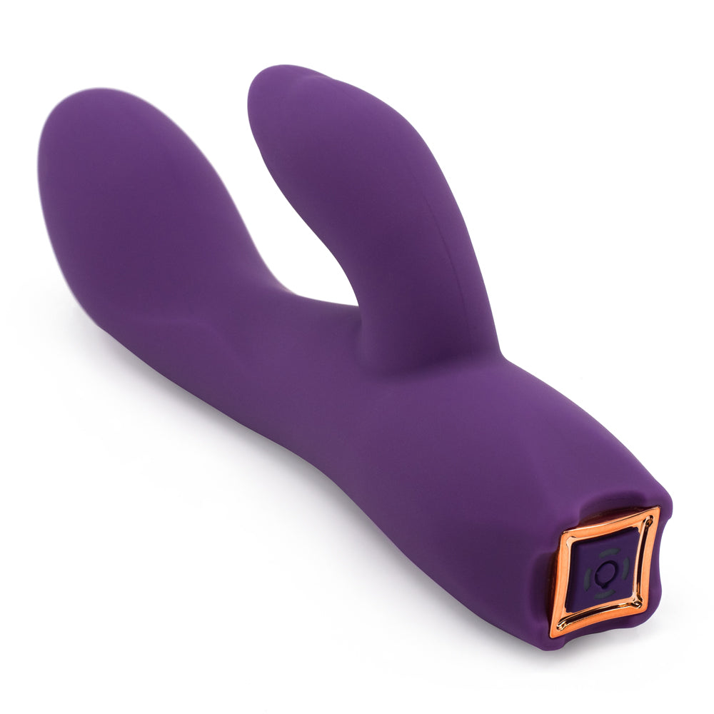 A dark purple silicone rabbit vibrator with a curved G spot shaft lays on a white background showing its control buttons.
