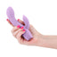 A manicured hand holds a light purple silicone G spot rabbit vibrator for scale.