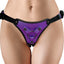 A female model wears a purple metallic vegan bonded leather harness strap-on with a metal O-ring in the centra. 