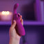 A close up of a model holding a Sexyland Embrace G Spot clitoral suction vibrator in her hand.