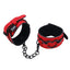 A pair of heart charm soft cuffs in red with black metal heart accents. 