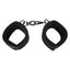 A pair of black velvet padded handcuffs with metal hooks sit against a white backdrop.