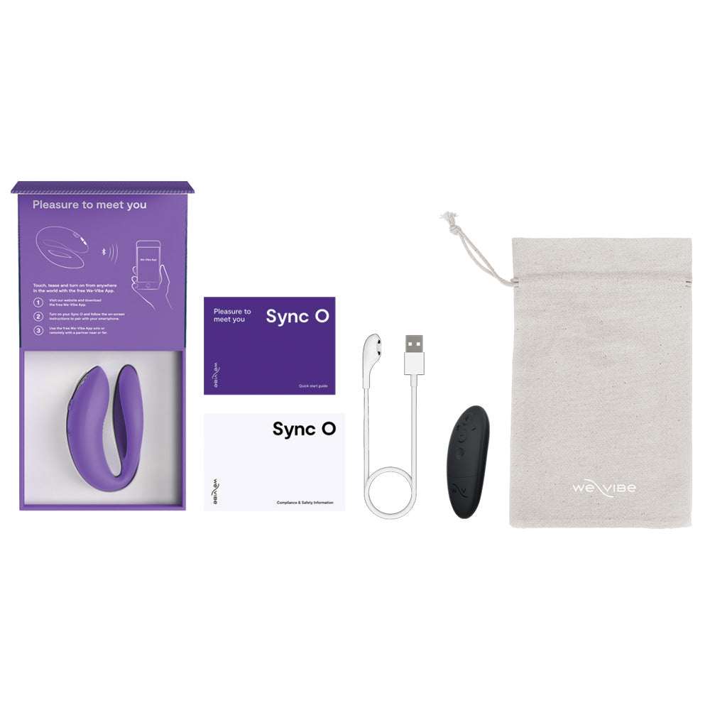 Flatlay of We-Vibe Sync O vibrator sits in its box next to its charging cord, instructions, remote control and bag.