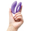 A models hand holds the We-Vibe Sync O secure fit app compatible coupes vibrator in purple.